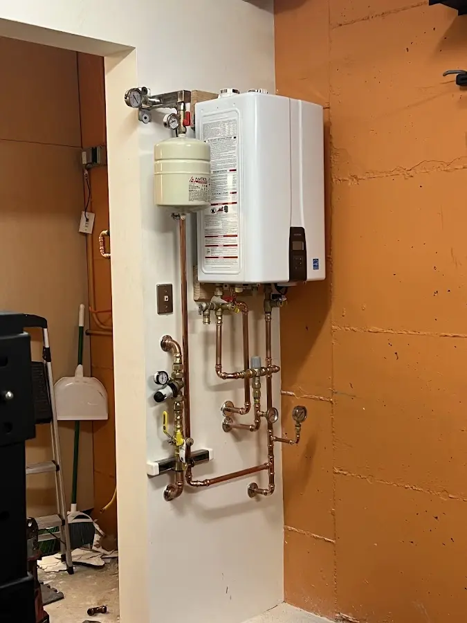 Plumbing technician inspecting water heater connections in Lawnside